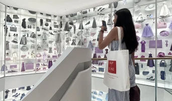 student taking picture in a luxury fashion brand store